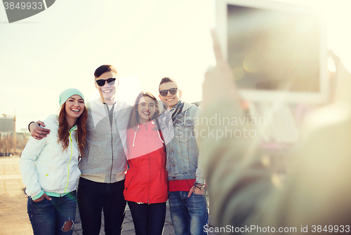 Image of happy teenage friends with tablet pc photographing