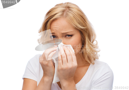 Image of unhappy woman with paper napkin blowing nose
