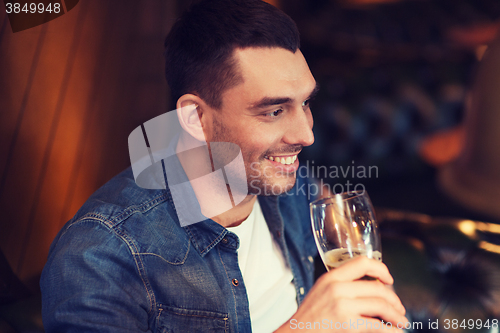 Image of happy man drinking beer at bar or pub