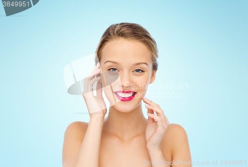 Image of smiling young woman with pink lipstick on lips