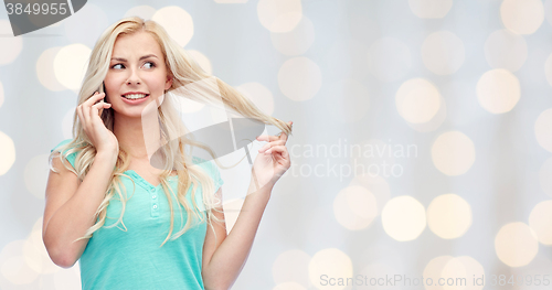 Image of smiling young woman calling on smartphone