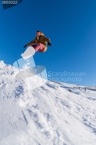 Image of Snowboarder jumping against blue sky