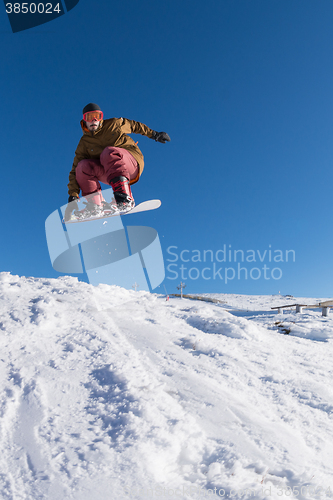 Image of Snowboarder jumping against blue sky