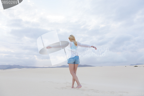 Image of Carefree woman enjoying freedom on beach.