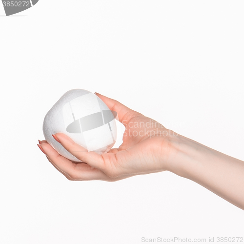 Image of The female hand holding white blank styrofoam oval 