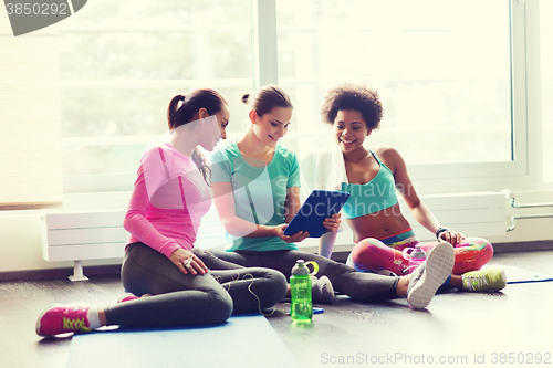Image of group of happy women with tablet pc in gym