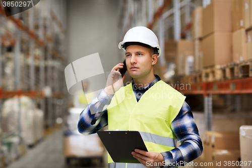 Image of man with clipboard and smartphone at warehouse