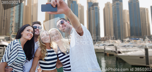 Image of happy friends taking selfie over city harbor