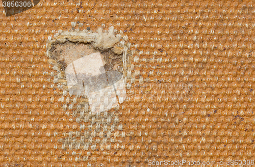 Image of Detail (damage) of an old canvas suitcase, close-up