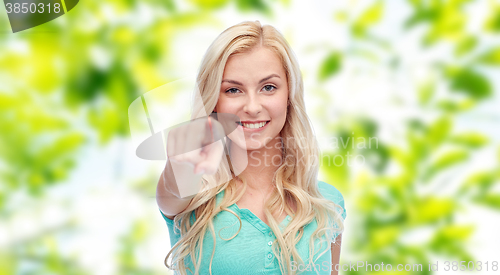 Image of happy young woman pointing finger to you