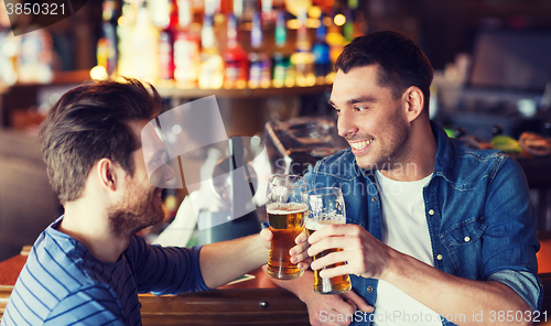 Image of happy male friends drinking beer at bar or pub