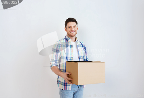 Image of smiling young man with cardboard box at home