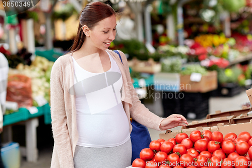 Image of pregnant woman choosing food at street market