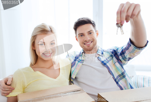 Image of happy couple with key and boxes moving to new home