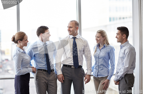 Image of smiling business people talking in office