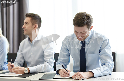 Image of group of smiling businesspeople meeting in office