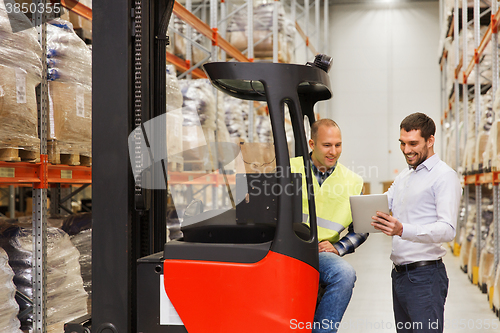 Image of men with tablet pc and forklift at warehouse