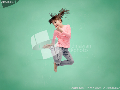 Image of happy little girl jumping in air over school board