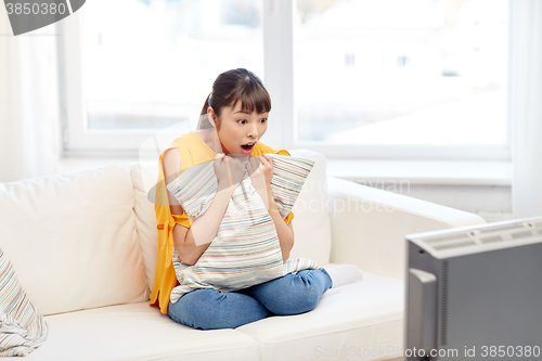 Image of asian young woman watching tv at home