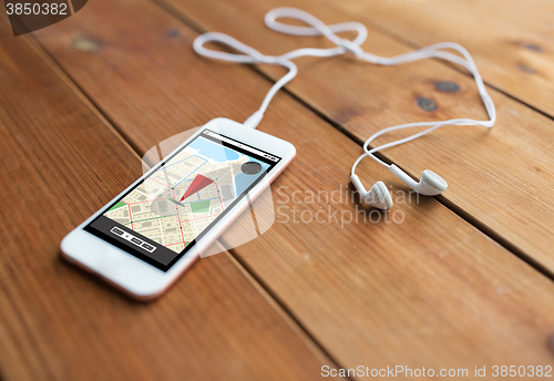 Image of close up of smartphone and earphones on wood