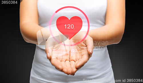 Image of close up of womans hands showing heart beat icon