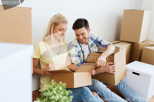 Image of smiling couple with many boxes moving to new home