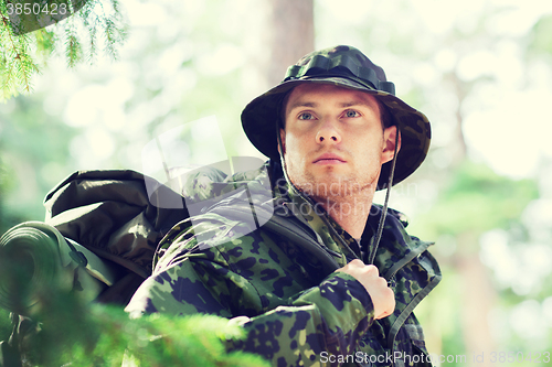 Image of young soldier with backpack in forest