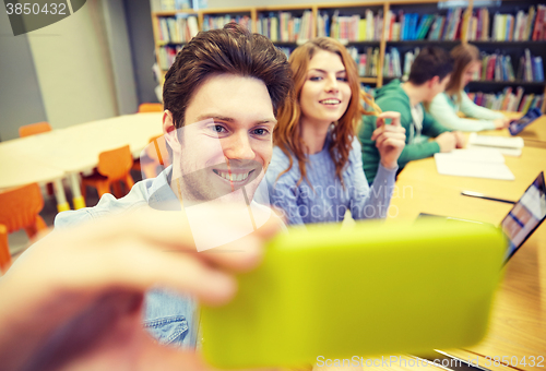 Image of students with smartphone taking selfie in library