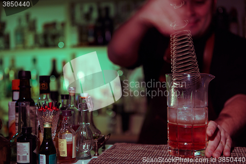 Image of Bartender nixed cocktail in glass cup.