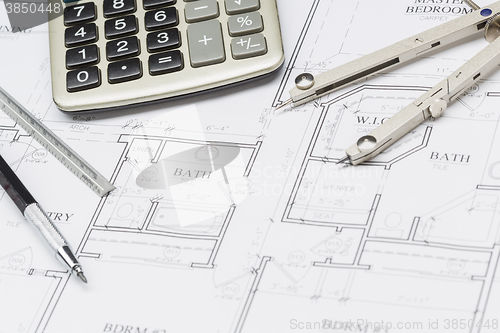 Image of Pencil, Ruler, Compass and Calculator Resting on House Plans