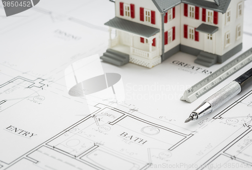 Image of Model Home, Engineer Pencil and Ruler Resting On House Plans