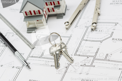 Image of Home, Pencil, Ruler, Compass and Key Resting on House Plans