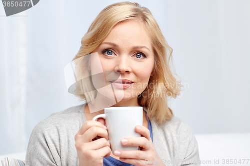 Image of woman with cup of tea or coffee at home