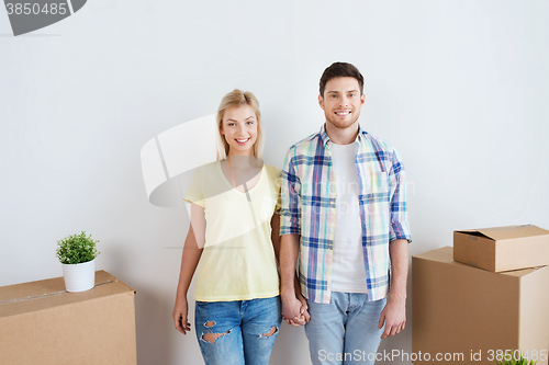 Image of smiling couple with big boxes moving to new home