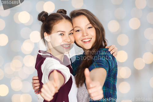 Image of happy smiling teenage girls showing thumbs up