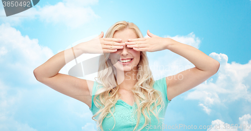 Image of smiling young woman or teen girl covering her eyes