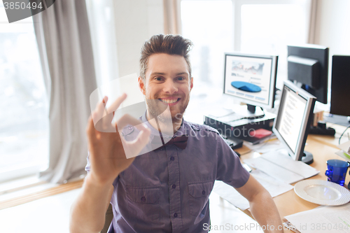 Image of happy creative male office worker showing ok sign