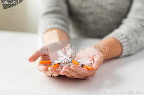 Image of close up of woman hands holding insulin syringes