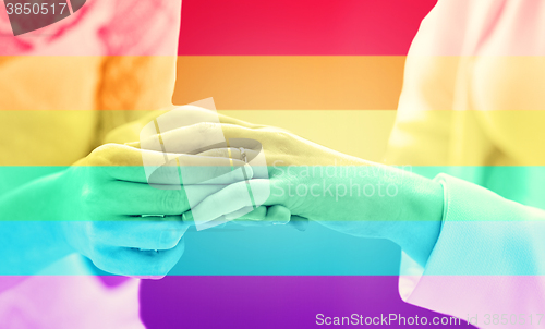 Image of close up of lesbian couple hands with wedding ring