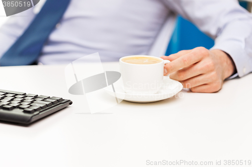 Image of close up of businessman hand with coffee cup