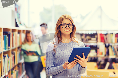 Image of happy student girl with tablet pc in library