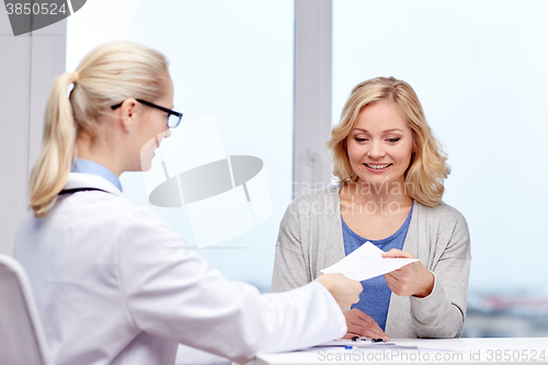 Image of doctor giving prescription to woman at hospital