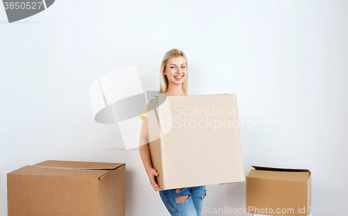 Image of smiling young woman with cardboard box at home