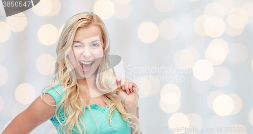 Image of smiling young woman holding her strand of hair