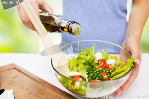 Image of close up of woman cooking vegetable salad at home