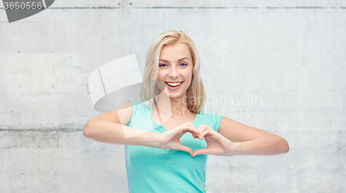 Image of happy woman or teen girl showing heart shape sigh