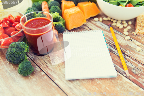 Image of close up of ripe vegetables and notebook on table