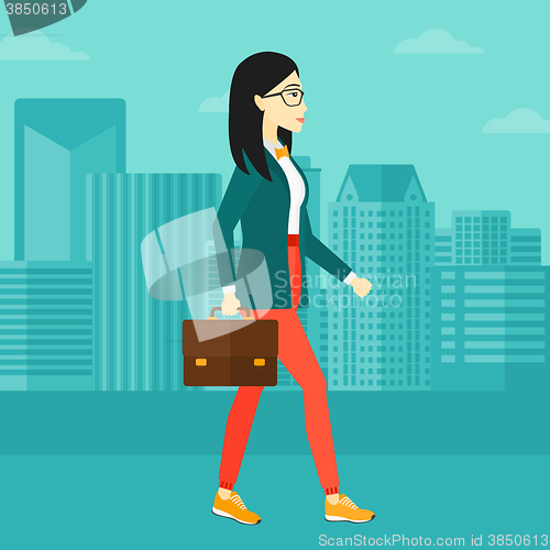 Image of Business woman walking with briefcase. 