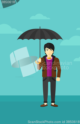 Image of Businessman standing with umbrella.