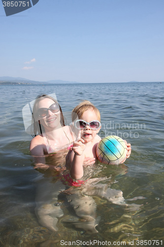 Image of Mother and daughter playing in the sea